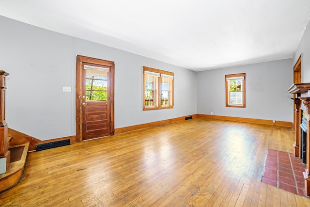 living room with a wealth of natural light and light hardwood / wood-style flooring