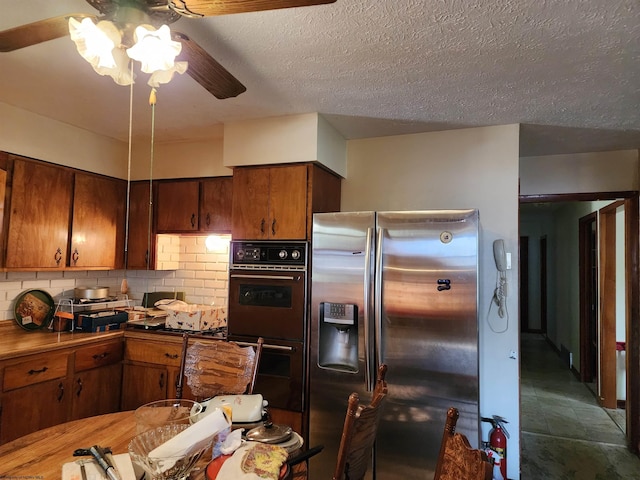 413 Green Acres Cir, Spencer, WV 25276 - kitchen with a ceiling fan, stainless steel refrigerator with ice dispenser, tasteful backsplash, a textured ceiling, and double oven