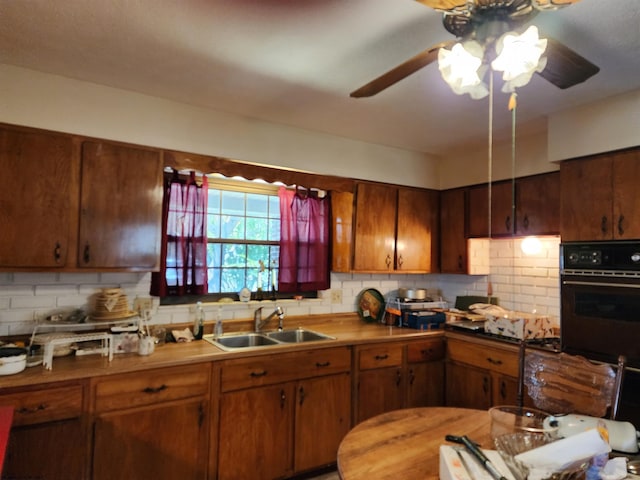 413 Green Acres Cir, Spencer, WV 25276 - kitchen with backsplash, black oven, ceiling fan, brown cabinetry, and a sink