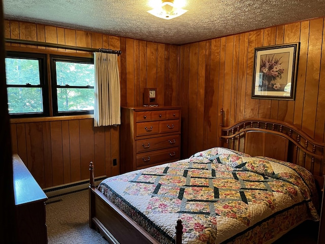 bedroom with wood walls, carpet flooring, a baseboard radiator, and a textured ceiling