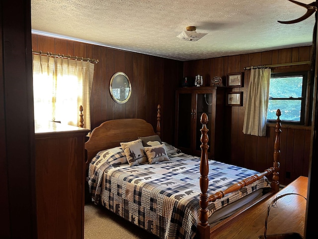 bedroom with a textured ceiling, light colored carpet, and multiple windows