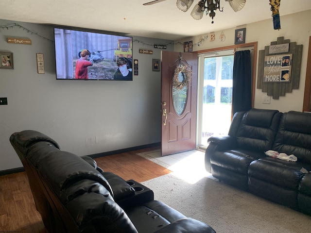 living room with baseboards, wood finished floors, and ceiling fan