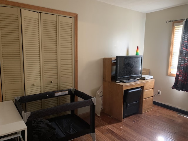 office area featuring baseboards, visible vents, and wood finished floors