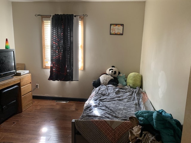 bedroom with dark wood-style floors and baseboards