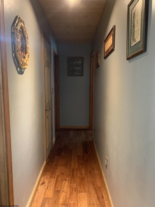 hall with baseboards and light wood-type flooring