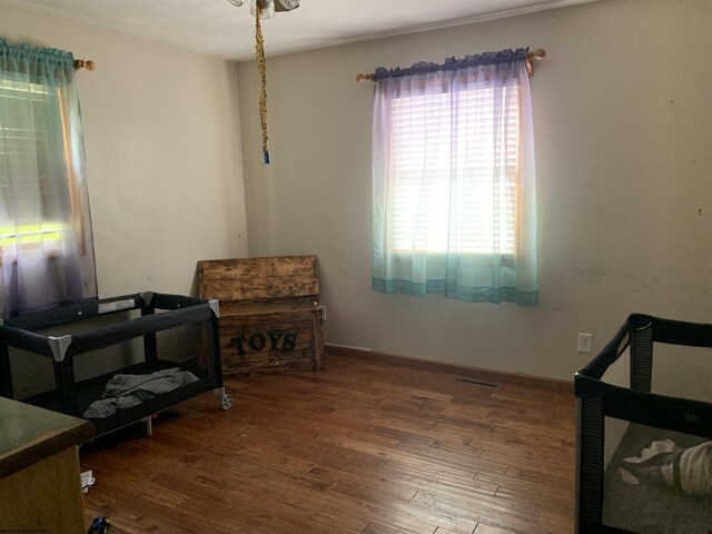 living area featuring visible vents, baseboards, and wood finished floors