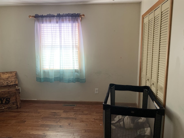 bedroom featuring a closet, visible vents, wood finished floors, and baseboards