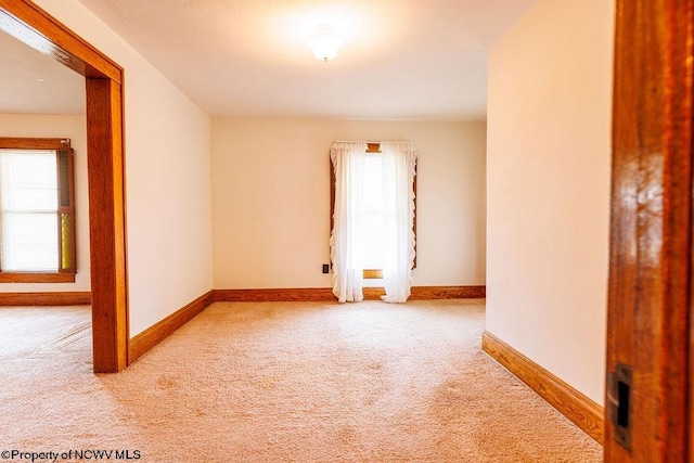 unfurnished room featuring light colored carpet