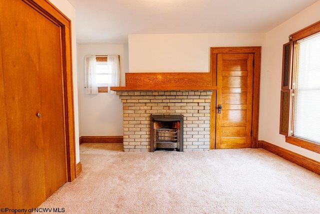 unfurnished living room featuring light colored carpet and a brick fireplace