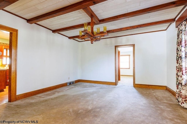 spare room with beamed ceiling and light colored carpet