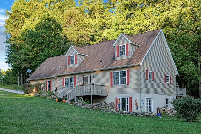 view of front facade with a wooden deck and a front lawn