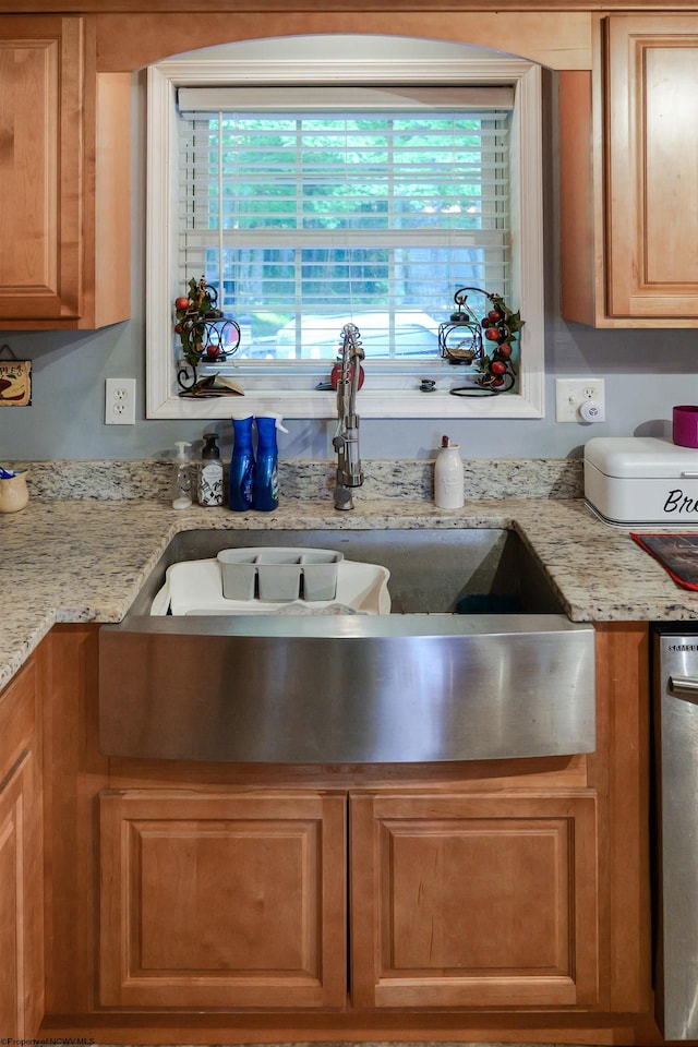 kitchen featuring light stone counters and sink