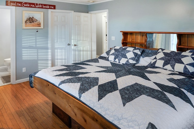 bedroom featuring crown molding, connected bathroom, and hardwood / wood-style flooring