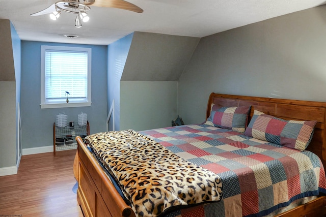 bedroom featuring ceiling fan, vaulted ceiling, and hardwood / wood-style flooring