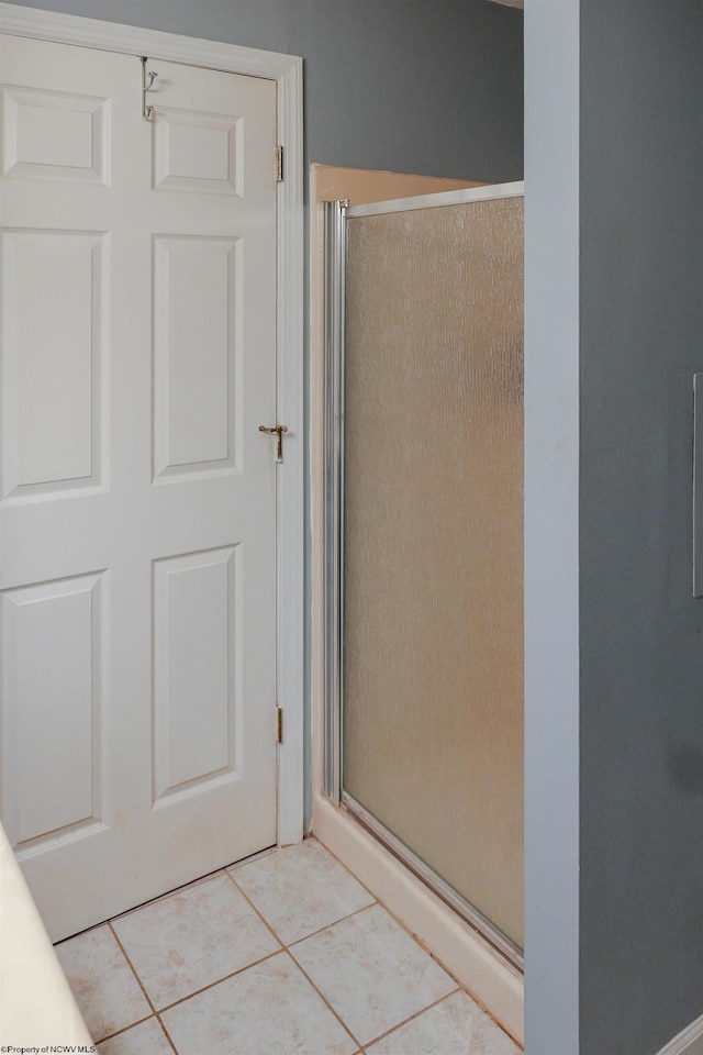 bathroom with tile patterned flooring and walk in shower