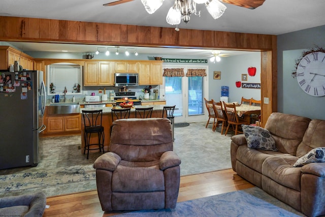 living room with ceiling fan, sink, and light hardwood / wood-style floors