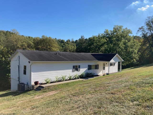 view of front of property with a front lawn and central AC unit