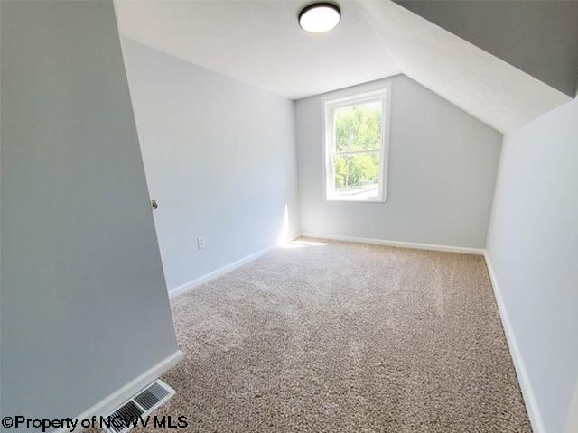 bonus room featuring lofted ceiling and carpet floors