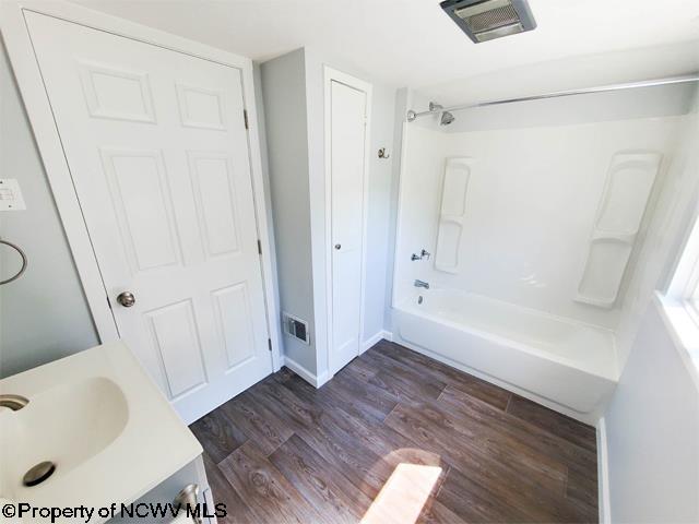 bathroom featuring vanity,  shower combination, and hardwood / wood-style flooring