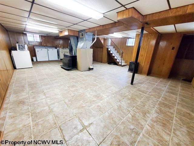 basement featuring washer / dryer and wooden walls