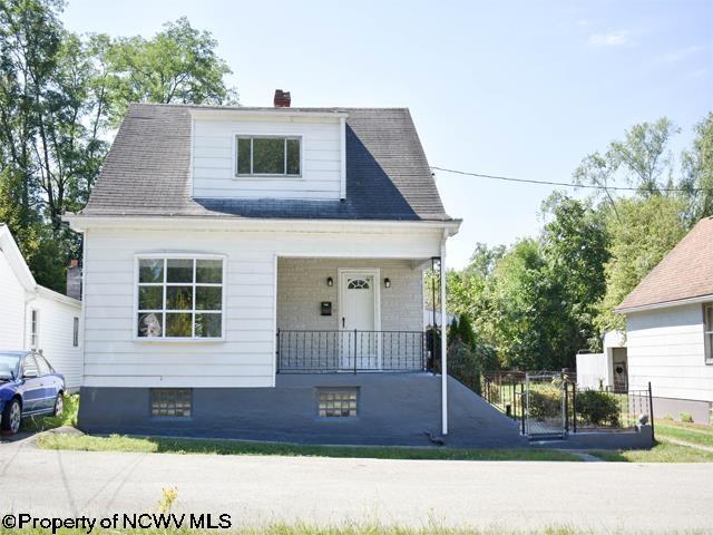 view of front of property featuring a porch, a chimney, and fence