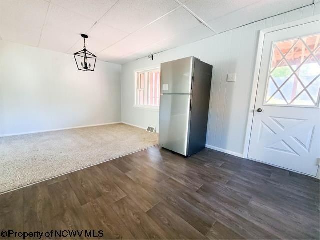 interior space featuring dark wood-type flooring, stainless steel refrigerator, and multiple windows