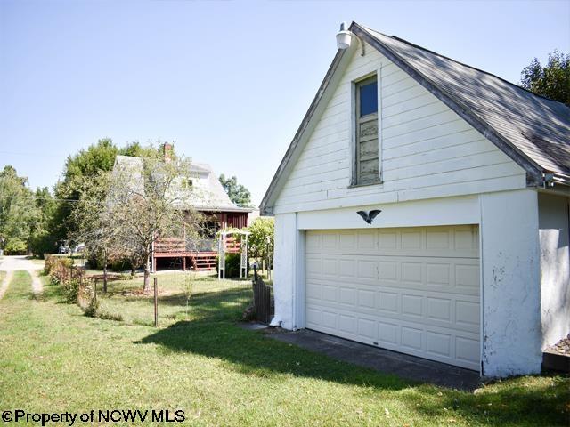 view of side of home featuring an outbuilding, a lawn, and a garage