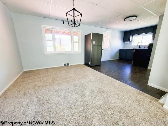 spare room featuring dark hardwood / wood-style floors, a chandelier, and sink