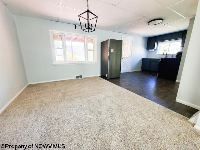 interior space featuring dark wood finished floors, visible vents, baseboards, and a drop ceiling