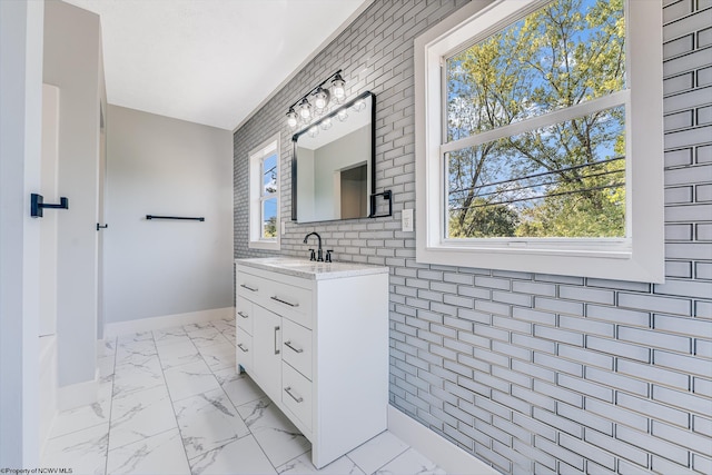 bathroom featuring vanity and brick wall