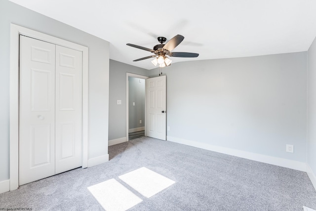 unfurnished bedroom featuring light colored carpet, ceiling fan, and a closet