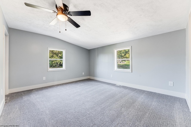 unfurnished room featuring carpet flooring, lofted ceiling, ceiling fan, and a textured ceiling