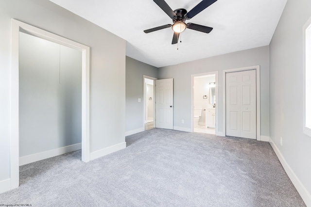 unfurnished bedroom with light carpet, ensuite bathroom, and ceiling fan