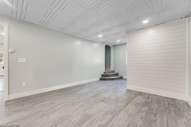 unfurnished room featuring light wood-type flooring and wooden walls