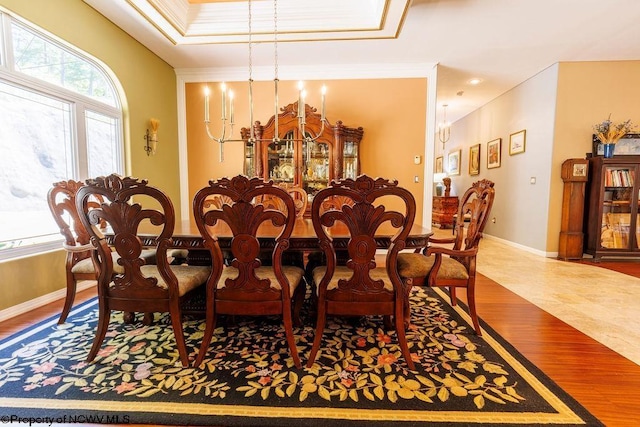 dining area featuring an inviting chandelier, crown molding, wood finished floors, and baseboards