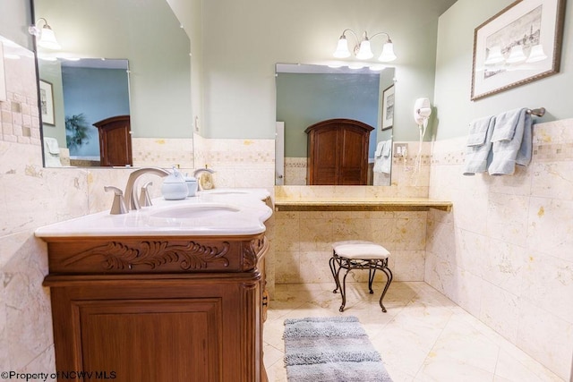 bathroom with tile walls, wainscoting, and vanity