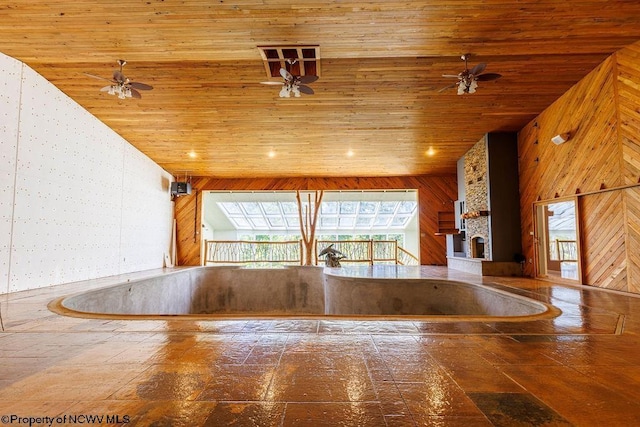 interior space with high vaulted ceiling, recessed lighting, stone tile flooring, wood walls, and wooden ceiling