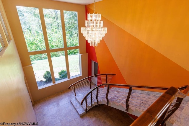 stairs featuring a chandelier