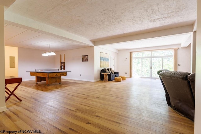 rec room featuring electric panel, light wood-style flooring, a textured ceiling, and baseboards