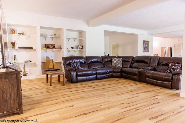 living room featuring beamed ceiling, built in shelves, and wood finished floors