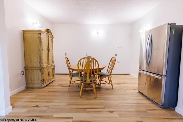 dining room with baseboards and light wood-style flooring