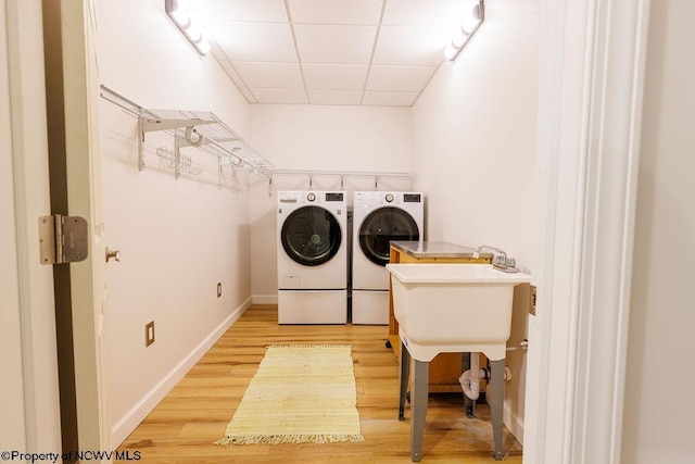 washroom with washer and dryer, laundry area, light wood-style flooring, and baseboards