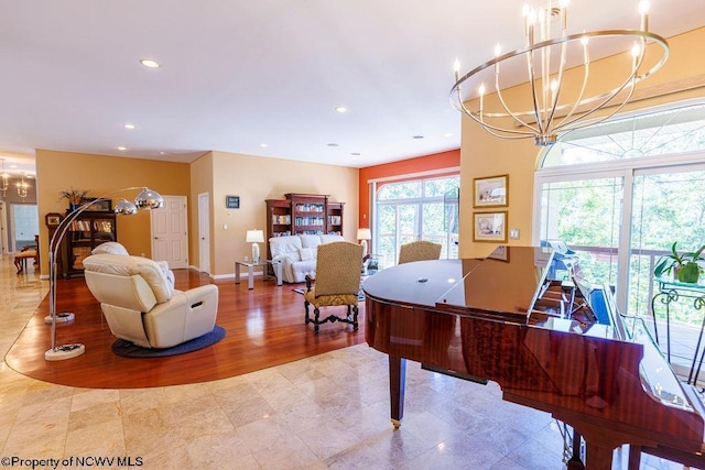 recreation room with recessed lighting, baseboards, an inviting chandelier, and wood finished floors