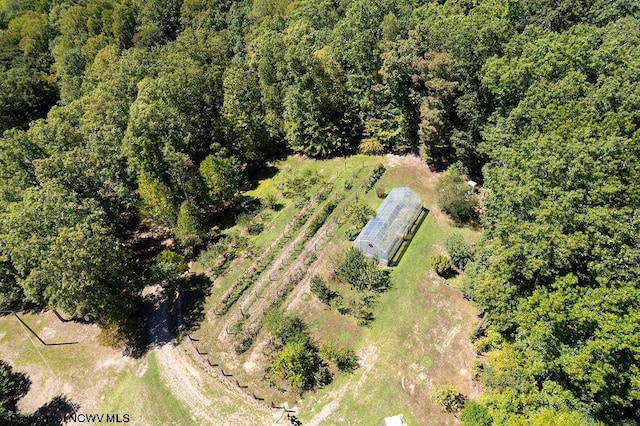 birds eye view of property featuring a wooded view