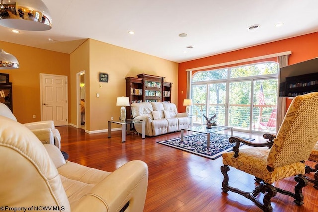 living area with recessed lighting, wood finished floors, and visible vents