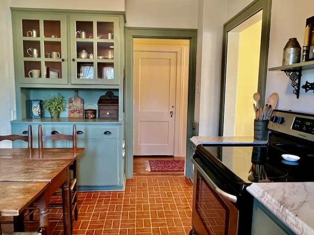 kitchen featuring electric stove and green cabinets