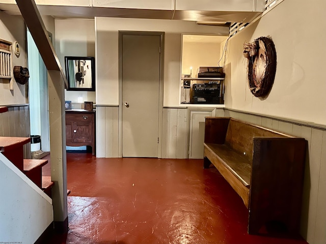 interior space featuring concrete flooring and wainscoting