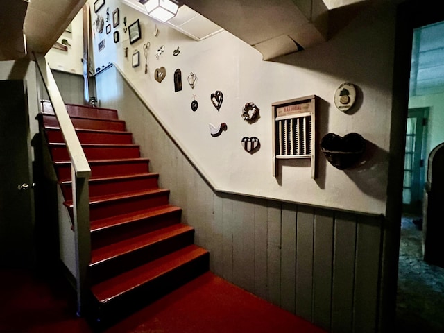 stairway with wooden walls and wainscoting