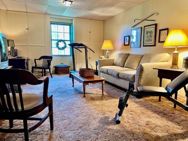 carpeted living room with a drop ceiling