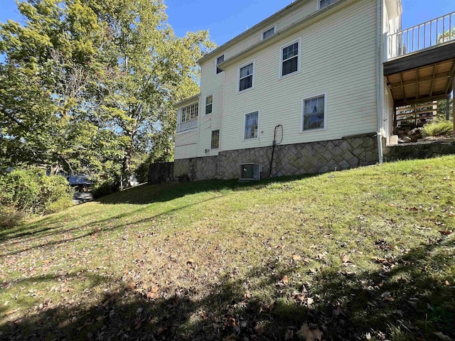 view of side of home featuring a yard and cooling unit